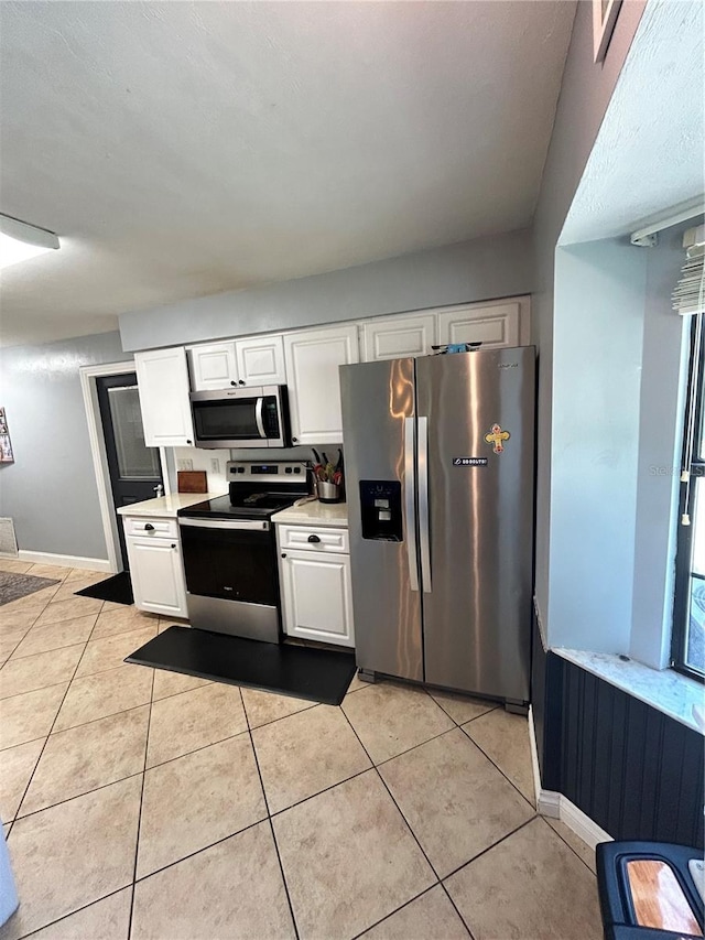 2070 SE 50th Ter, Ocala, FL 34480 - kitchen with appliances with stainless steel finishes, light countertops, white cabinetry, and light tile patterned flooring