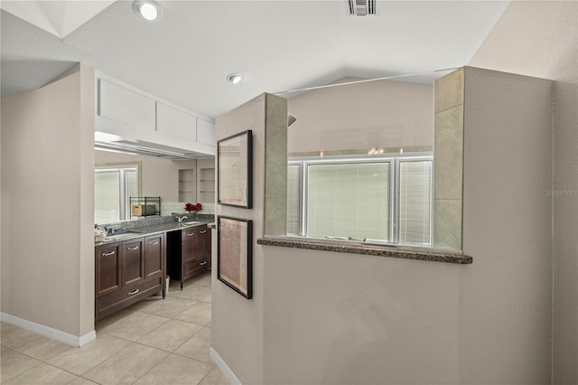 5002 SE 7th Pl, Ocala, FL 34471 - kitchen with light tile patterned flooring, dark brown cabinets, lofted ceiling, and stone counters