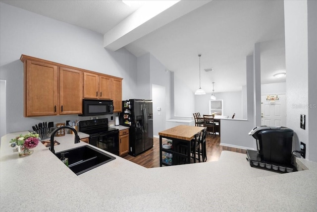3946 SW 133rd Loop, Ocala, FL 34473 - kitchen featuring black appliances, brown cabinetry, dark wood-style floors, beamed ceiling, and light countertops