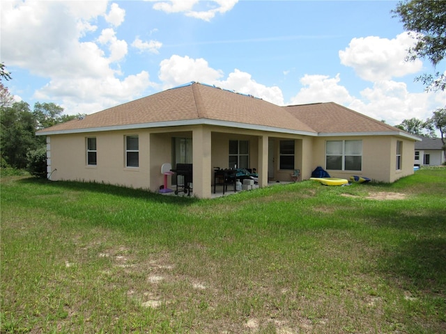 2640 SW 154th Place Rd, Ocala, FL 34473 - rear view of house with stucco siding, a patio, a yard, and a shingled roof