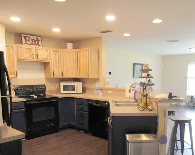 2640 SW 154th Place Rd, Ocala, FL 34473 - kitchen with black appliances, light brown cabinetry, a peninsula, a breakfast bar area, and recessed lighting