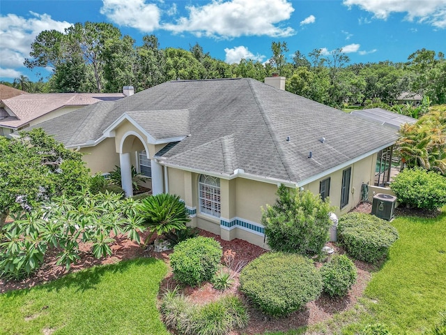 5210 Camberlea Ave, Zephyrhills, FL 33541 - view of front of home with a shingled roof, stucco siding, a chimney, and a front lawn