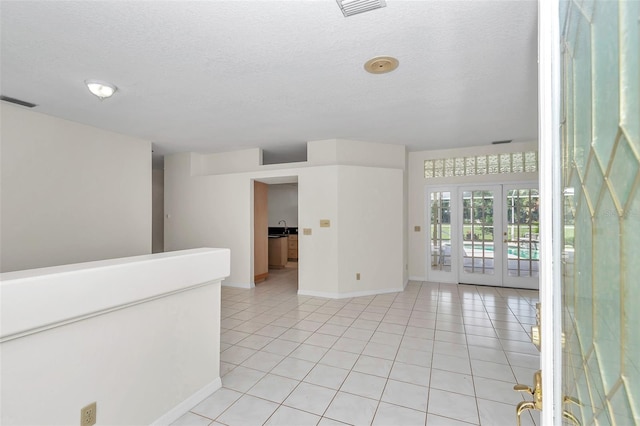 5210 Camberlea Ave, Zephyrhills, FL 33541 - spare room featuring a textured ceiling, light tile patterned floors, and french doors