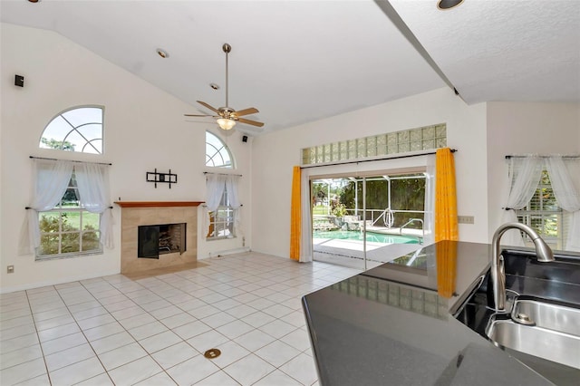 5210 Camberlea Ave, Zephyrhills, FL 33541 - living area with a ceiling fan, high vaulted ceiling, a fireplace, and light tile patterned floors