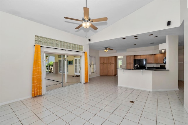 5210 Camberlea Ave, Zephyrhills, FL 33541 - unfurnished living room with ceiling fan, plenty of natural light, light tile patterned flooring, and high vaulted ceiling