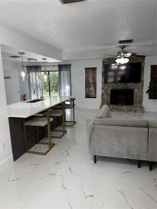 3585 N Hiawatha Ter, Crystal River, FL 34428 - living area with a textured ceiling, a ceiling fan, light marble finish floors, and a fireplace