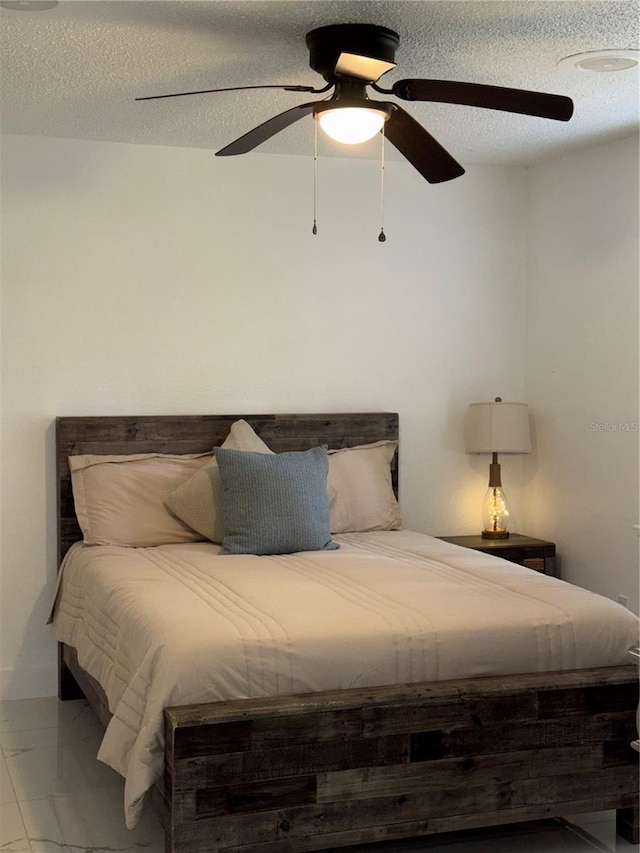 3585 N Hiawatha Ter, Crystal River, FL 34428 - bedroom with marble look tile flooring, a textured ceiling, and a ceiling fan