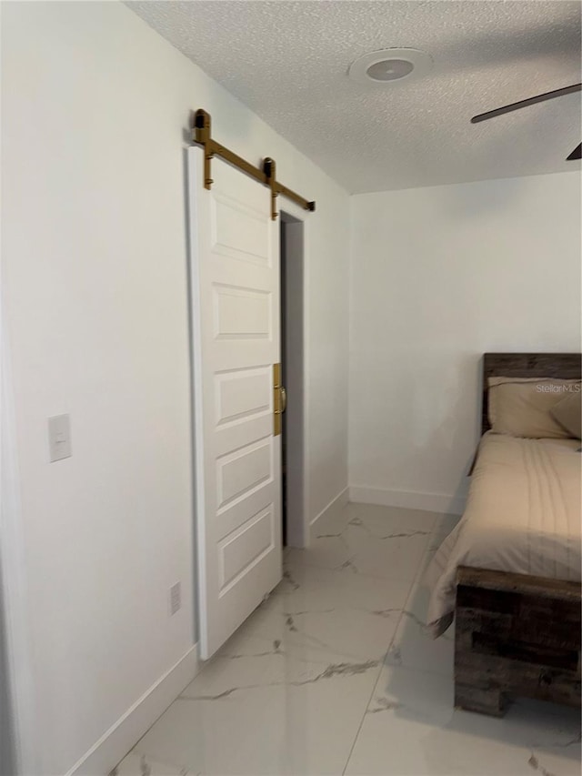 3585 N Hiawatha Ter, Crystal River, FL 34428 - bedroom with a barn door, marble finish floors, a textured ceiling, and ceiling fan