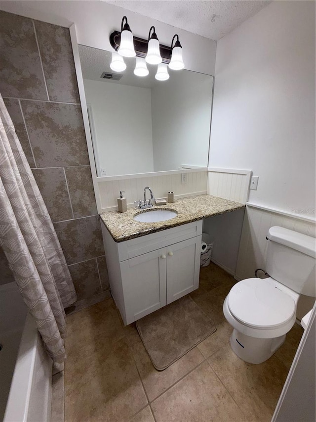 3585 N Hiawatha Ter, Crystal River, FL 34428 - bathroom with vanity, wainscoting, a textured ceiling, and tile patterned flooring