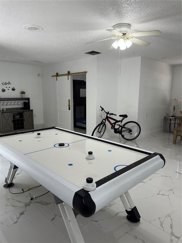 3585 N Hiawatha Ter, Crystal River, FL 34428 - playroom with marble look tiles, a textured ceiling, ceiling fan, and a barn door