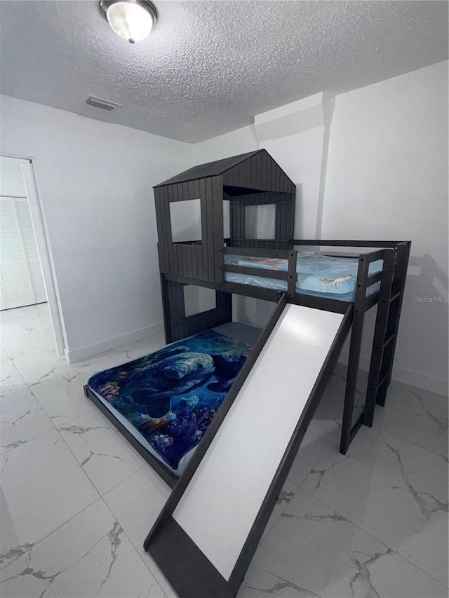 3585 N Hiawatha Ter, Crystal River, FL 34428 - bedroom with marble look tiles and a textured ceiling