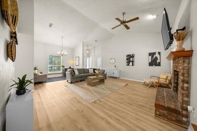 3520 NW 46th Ter, Gainesville, FL 32606 - living area with wood finished floors, a ceiling fan, a chandelier, a brick fireplace, and high vaulted ceiling