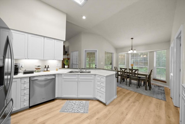 3520 NW 46th Ter, Gainesville, FL 32606 - kitchen featuring appliances with stainless steel finishes, a peninsula, light wood-style flooring, light countertops, and white cabinets