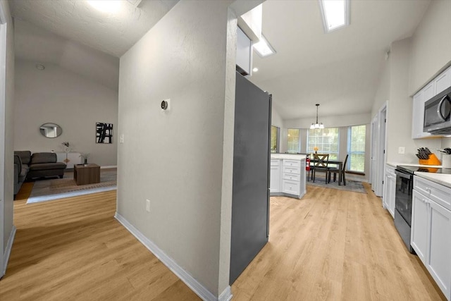 3520 NW 46th Ter, Gainesville, FL 32606 - hallway featuring lofted ceiling, light wood-style flooring, and a chandelier