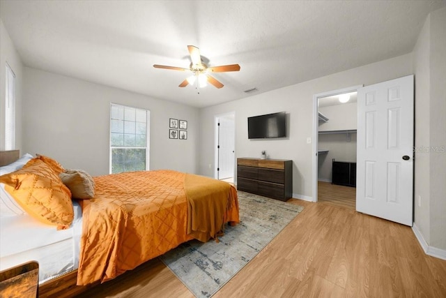3520 NW 46th Ter, Gainesville, FL 32606 - bedroom with light wood-type flooring, a spacious closet, a ceiling fan, and a closet