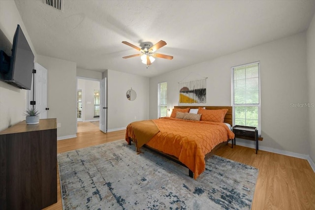 3520 NW 46th Ter, Gainesville, FL 32606 - bedroom featuring multiple windows, light wood-style flooring, and a ceiling fan