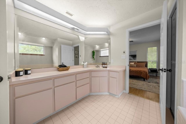 3520 NW 46th Ter, Gainesville, FL 32606 - ensuite bathroom featuring vanity, tile patterned floors, healthy amount of natural light, and a textured ceiling