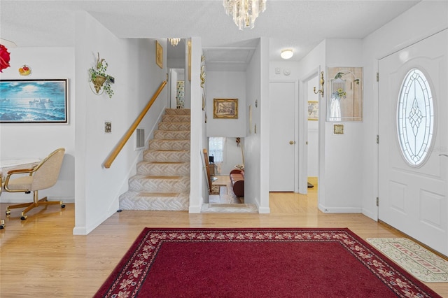 6 Emerald Crse, Ocala, FL 34472 - foyer entrance featuring wood finished floors, a chandelier, stairs, and a textured ceiling