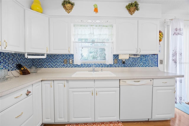 6 Emerald Crse, Ocala, FL 34472 - kitchen featuring white dishwasher, white cabinets, tasteful backsplash, light countertops, and light wood-type flooring