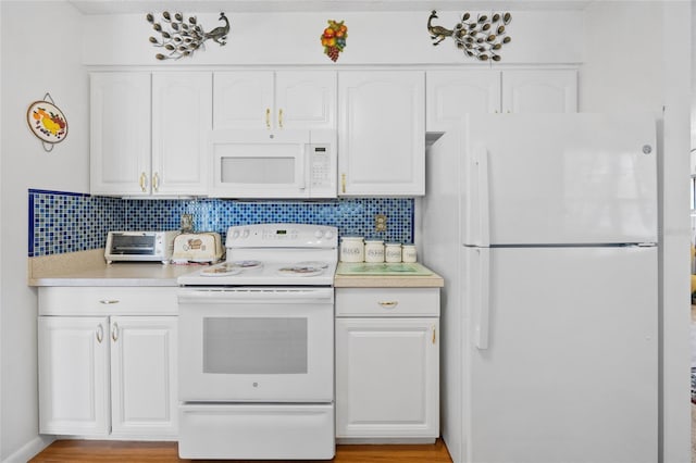 6 Emerald Crse, Ocala, FL 34472 - kitchen featuring white appliances, white cabinetry, decorative backsplash, and light countertops