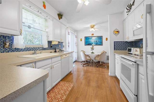 6 Emerald Crse, Ocala, FL 34472 - kitchen with white appliances, ceiling fan, white cabinets, and decorative backsplash