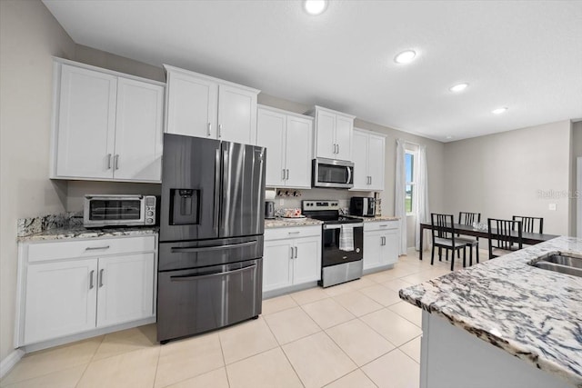 5833 SW 85th Pl, Ocala, FL 34476 - kitchen with appliances with stainless steel finishes, white cabinets, light stone countertops, recessed lighting, and light tile patterned flooring