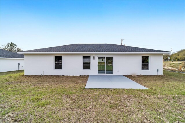 15115 SW 39th Cir, Ocala, FL 34473 - back of property with a patio, stucco siding, a yard, and roof with shingles