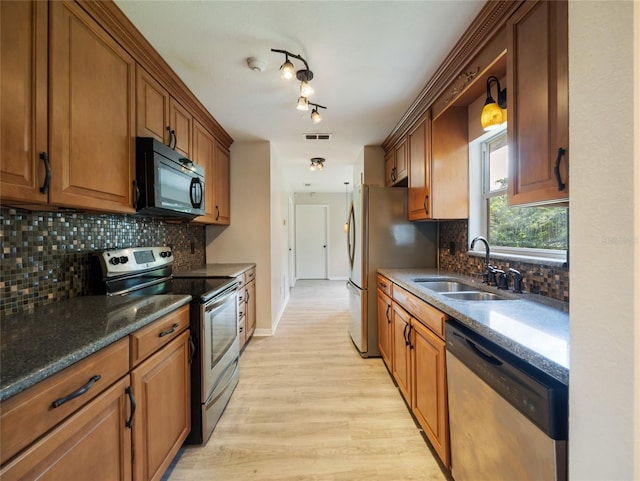 17 Pecan Run Hbr, Ocala, FL 34472 - kitchen with appliances with stainless steel finishes, light wood finished floors, backsplash, brown cabinetry, and dark stone counters