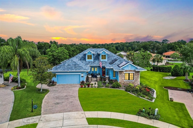 5233 Fountain Walk, Lady Lake, FL 32159 - view of front of home featuring driveway, stone siding, a front yard, and an attached garage