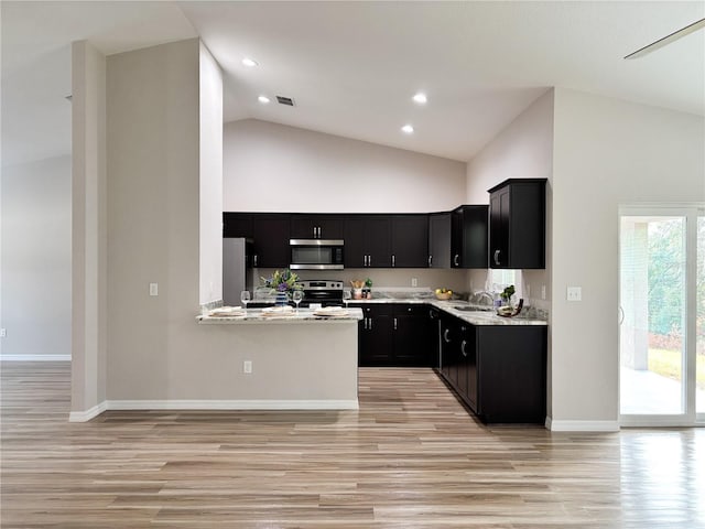 6431 SW 145th Lane Rd, Ocala, FL 34473 - kitchen featuring appliances with stainless steel finishes, dark cabinetry, high vaulted ceiling, light wood-type flooring, and light countertops