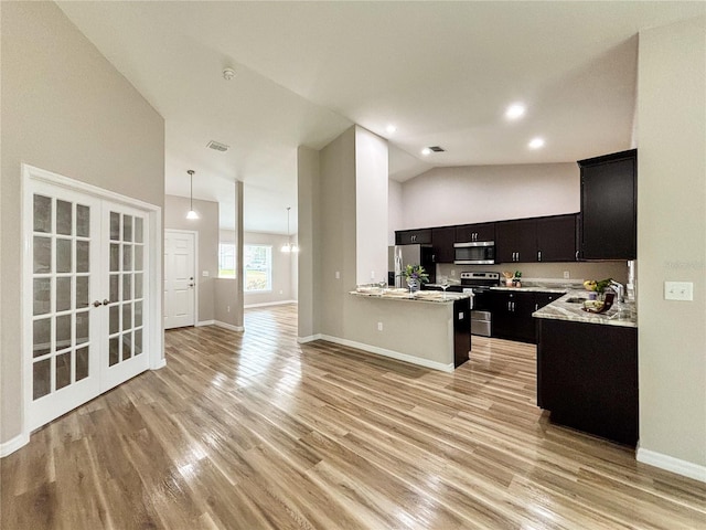 6431 SW 145th Lane Rd, Ocala, FL 34473 - kitchen with stainless steel appliances, dark cabinets, open floor plan, light countertops, and lofted ceiling