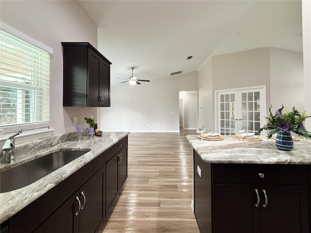 6431 SW 145th Lane Rd, Ocala, FL 34473 - kitchen featuring vaulted ceiling, a ceiling fan, light wood-type flooring, light stone counters, and french doors