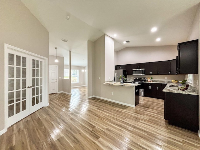6431 SW 145th Lane Rd, Ocala, FL 34473 - kitchen with stainless steel appliances, dark cabinetry, open floor plan, light wood-type flooring, and french doors