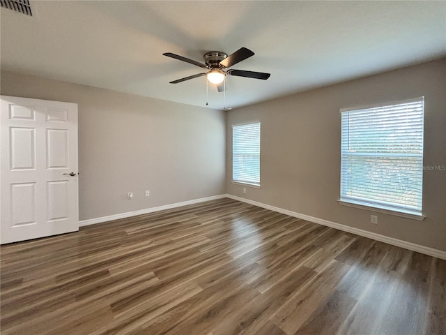 6431 SW 145th Lane Rd, Ocala, FL 34473 - empty room featuring plenty of natural light, dark wood finished floors, and a ceiling fan