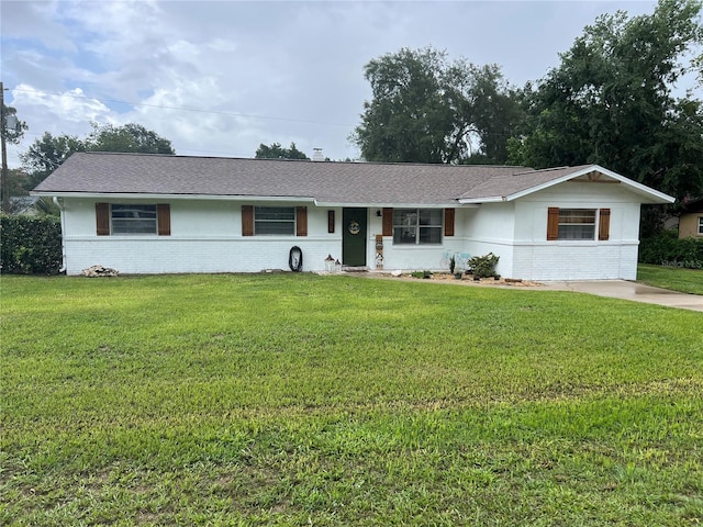 5561 NE 5th Pl, Ocala, FL 34470 - single story home featuring brick siding, a front lawn, and roof with shingles