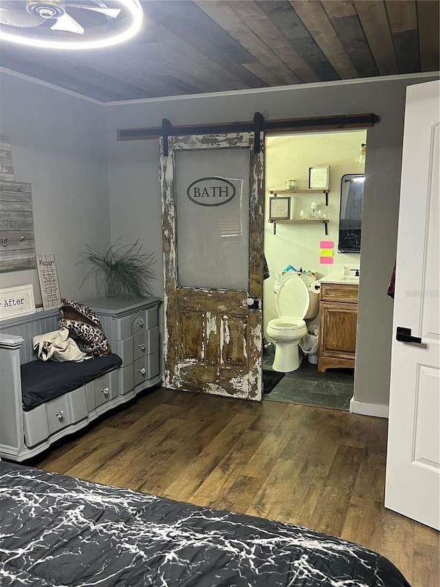 5561 NE 5th Pl, Ocala, FL 34470 - bedroom with dark wood-style floors, a barn door, ensuite bath, and ornamental molding