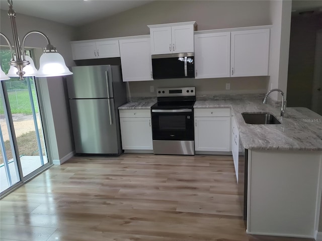 2869 SE 142nd Pl, Summerfield, FL 34491 - kitchen featuring stainless steel appliances, light wood-style flooring, white cabinets, light stone countertops, and lofted ceiling