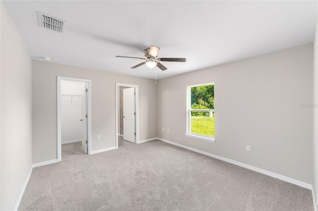 2869 SE 142nd Pl, Summerfield, FL 34491 - unfurnished bedroom featuring a spacious closet, carpet, a ceiling fan, and a closet
