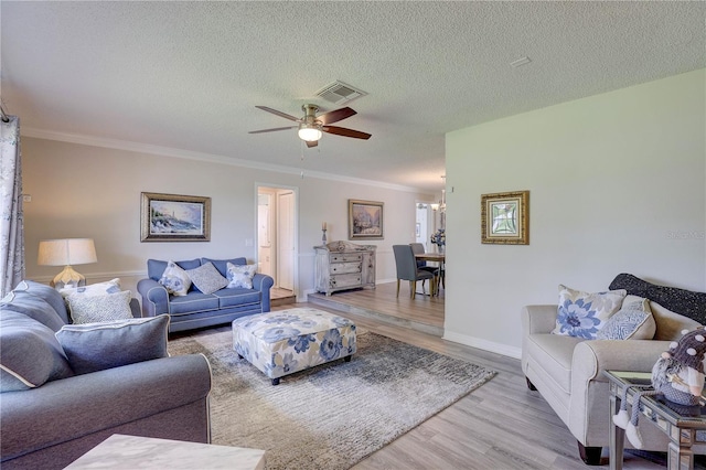13006 Pebble Beach Cir, Hudson, FL 34667 - living area featuring wood finished floors, ceiling fan, ornamental molding, a textured ceiling, and a chandelier