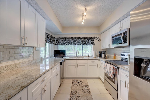 13006 Pebble Beach Cir, Hudson, FL 34667 - kitchen featuring stainless steel appliances, white cabinets, light stone countertops, tasteful backsplash, and light tile patterned floors