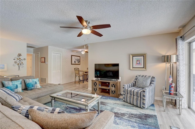 13006 Pebble Beach Cir, Hudson, FL 34667 - living area featuring light wood-style flooring, a ceiling fan, and a textured ceiling
