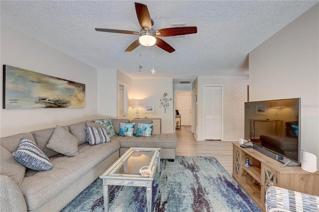 13006 Pebble Beach Cir, Hudson, FL 34667 - living area featuring a textured ceiling, a ceiling fan, and wood finished floors