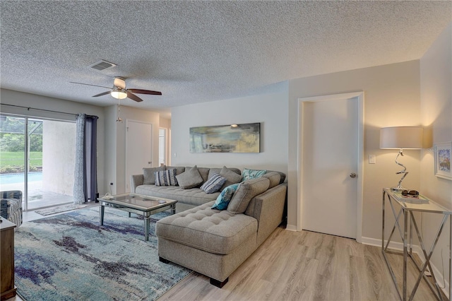 13006 Pebble Beach Cir, Hudson, FL 34667 - living room with a ceiling fan, light wood finished floors, and a textured ceiling