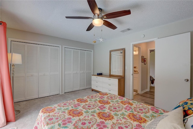 13006 Pebble Beach Cir, Hudson, FL 34667 - bedroom featuring multiple closets, a textured ceiling, and ceiling fan