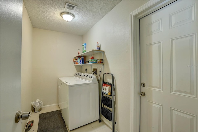 13006 Pebble Beach Cir, Hudson, FL 34667 - laundry area featuring washer and clothes dryer, a textured ceiling, and light tile patterned flooring