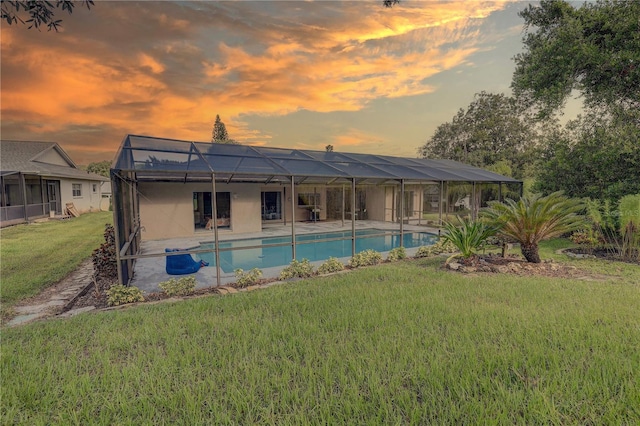 13006 Pebble Beach Cir, Hudson, FL 34667 - back of property featuring an outdoor pool, a lawn, glass enclosure, and a patio area