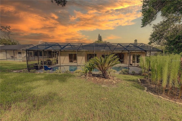 13006 Pebble Beach Cir, Hudson, FL 34667 - back of house at dusk with glass enclosure, an outdoor pool, and a yard