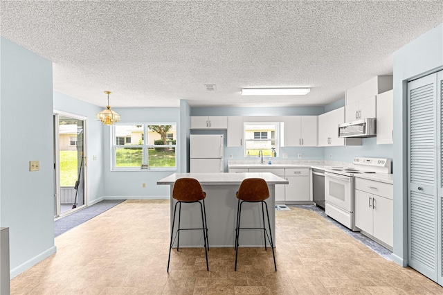9664 SW 94th Ter Unit A, Ocala, FL 34481 - kitchen featuring stainless steel appliances, a center island, light countertops, a breakfast bar, and a textured ceiling