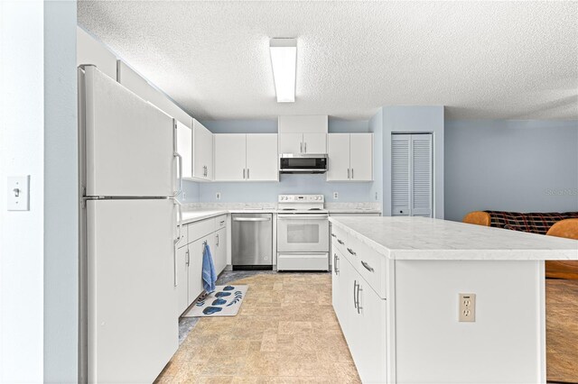 9664 SW 94th Ter Unit A, Ocala, FL 34481 - kitchen featuring appliances with stainless steel finishes, light countertops, a kitchen island, a textured ceiling, and white cabinetry
