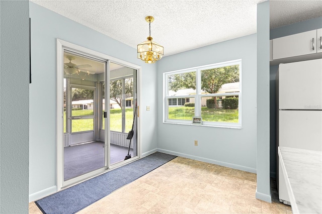 9664 SW 94th Ter Unit A, Ocala, FL 34481 - unfurnished dining area featuring a chandelier, a textured ceiling, and light floors